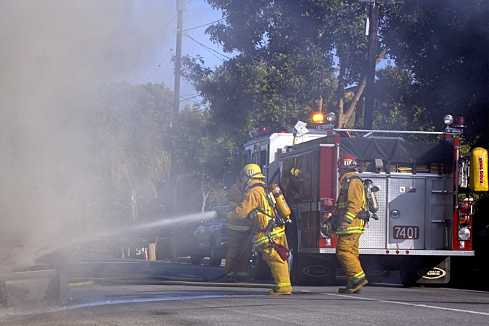 fireman leaning into his hose